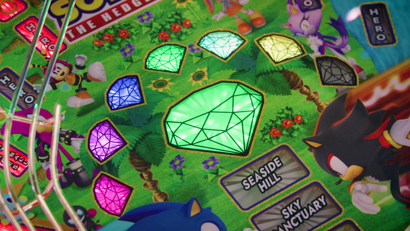 Primer plano del playfield superior de Sonic the Hedgehog con las siete Chaos Emeralds iluminadas junto a Knuckles, Shadow y Blaze