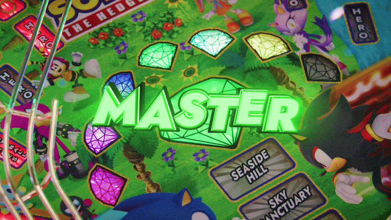 Fotograma del playfield superior de Sonic the Hedgehog con el rótulo animado "MASTER" iluminado en verde sobre las Chaos Emeralds